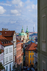 Beautiful aerial view St. Nicholas Church in the Lesser Town of Prague, Czech Republic — stunning baroque masterpiece surrounded by colorful old buildings and cobblestone streets