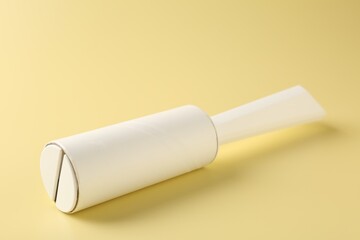 One lint roller on yellow background, closeup