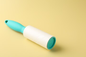 One lint roller on yellow background, closeup. Space for text
