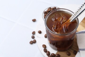 Tasty iced coffee and beans on white table, closeup. Space for text