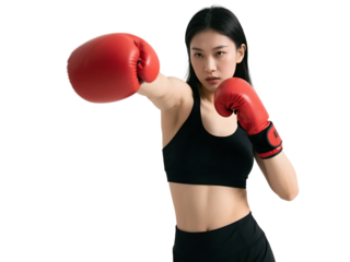 A young woman in black sportswear with red boxing gloves is performing a punching action, showcasing fitness and sport.
