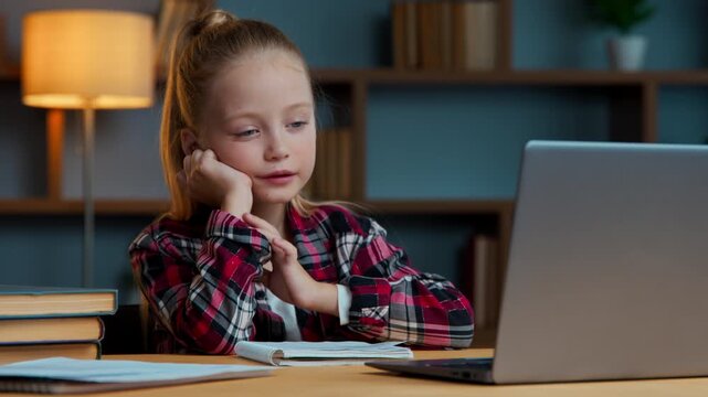 Sleepy Caucasian girl child kid daughter yawning studying online at home feeling tired yawn exhausted e-learning course sleepy watching virtual lesson learn study with internet bored at night evening