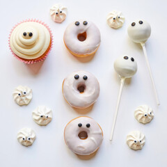 Obraz premium Delightful halloween treats spooky donuts and ghostly cupcakes kitchen food photography whimsical close-up festive desserts