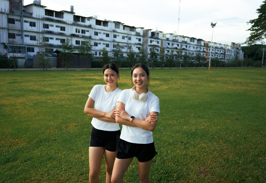 Two young women standing in park enjoying fitness