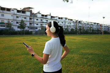 Young woman listening to music with headphones in park