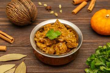 Agneau Masala – curry d’agneau épicé, spécialité indienne et sri-lankaise, servi sur une table en bois
