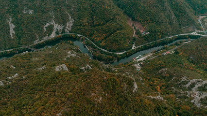 Aerial view of the Western Morava River winding through forested mountains below Mount Kablar in central Serbia, showcasing natural beauty and scenic autumn landscape.