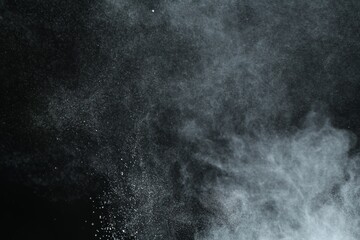 Talcum powder flying on black background, closeup