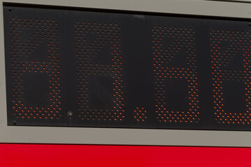 fuel price display, closeup of fuel price board at station, digital fuel price display with worn casing and reflective dots, station manager reviews digital fuel prices on aging led board for daily © Viktar