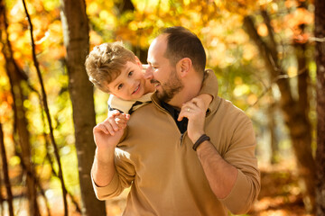 A portrait of a father with child in the autumn park