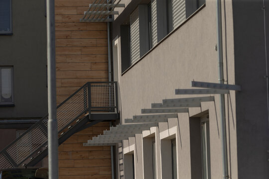 industrial architectural shadow patterns, metal staircase casting striking geometric shadows outdoors, industrialstyle metal staircase creating bold geometric shadows in urban architectural - Powered by Adobe