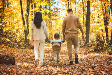 Fototapeta premium Beautiful young family on a walk in autumn forest