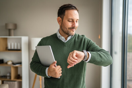 Man checking smart watch with holding tablet - Powered by Adobe