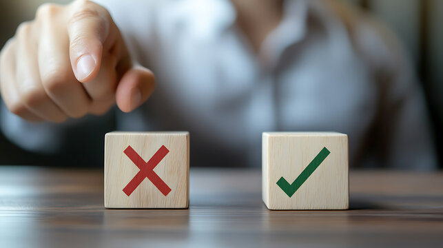 A person's finger points towards a wooden block with a green checkmark, symbolizing correct choices and decisions. Contrasting a block with a red X for incorrect options.