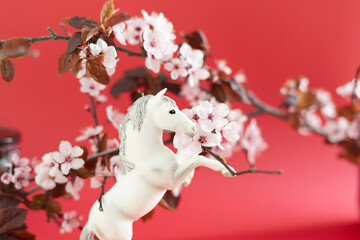 White horse with plum flowers around him. Celebration of the Chinese New Year 2026. Year of the horse.