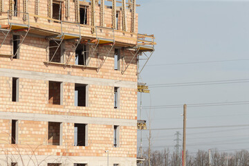 construction progress snapshot, building under construction overview, progress of building construction with scaffolding present, partial view showing ongoing construction work and visible scaffolding