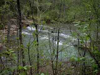 Wide cascading waterfall in ozark National Forest in Arkansas viewed through trees
