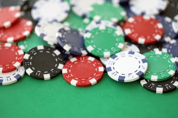 Casino gaming background with stacks of betting chips of different colors on green gaming mat