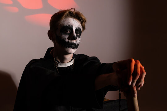 Young vampire boy holding a bat, ready for trick-or-treating on Halloween night - Powered by Adobe