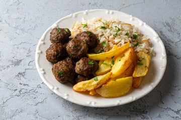 Round shaped balls of dry meatballs and french fries. Turkish name; kuru kofte ve patates