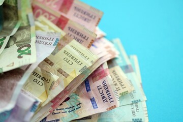 Ukrainian money bills on light blue paper background