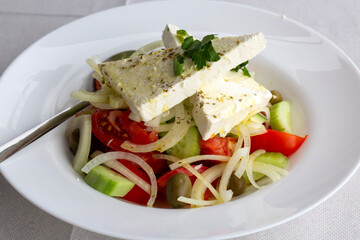 Greek salad with fresh vegetables, feta cheese and kalamata olives. Healthy food.