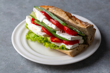 A cold sandwich made with white cheese, tomatoes, cucumbers and greens between bread. Turkish name: ekmek arasi peynir domates