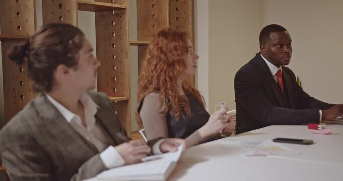 Business professionals collaborate in a startup meeting, discussing data and strategizing. The team actively participates, fostering innovation and growth. - Powered by Adobe