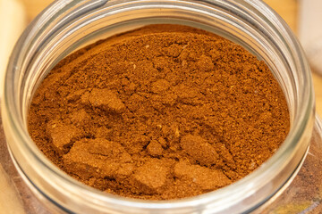 Top view of ground coffee in a glass jar, highlighting texture and deep brown color. Ideal for product packaging, coffee branding, cafe menu design, and beverage photography.