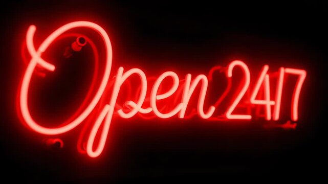 A bright red neon sign displays the words 'Open 24/7' in a cursive and block font. The sign is illuminated against a black background, creating a stark contrast.