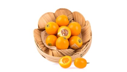 A group of vibrant, orange fruits nestled in a woven, wooden bowl