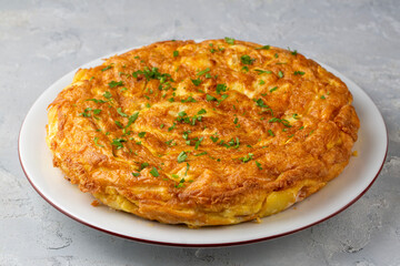 Spanish omelette with potatoes, typical spanish cuisine on gray concrete floor. Tortilla Espanola. Turkish name; Yumurtali patates