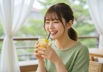 爽やかなテラスで冷たいレモネードを飲む笑顔の女性
