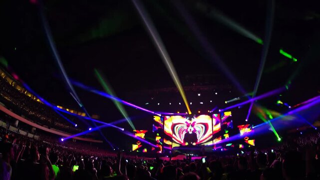 Cheering crowd at a music festival with colorful stage lights