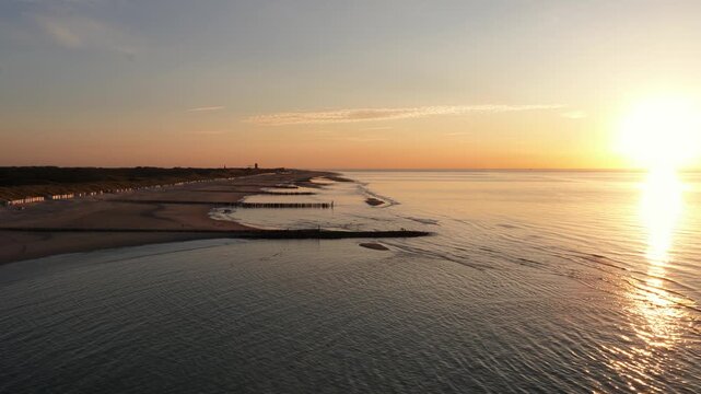 the coastline of Zeeland at sunset, golden hour, Domburg, wave breakers, sandy beach.