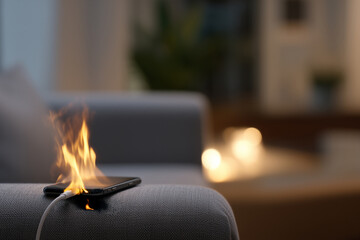 Smartphone catching fire while charging on sofa in living room causing fire accident