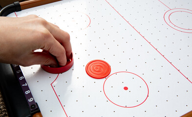 Hand ready to hit with paddle on puck. The portable table hockey includes plastic hockey paddles, a mini puck and score keepers. Hobby game background with copy space. High quality