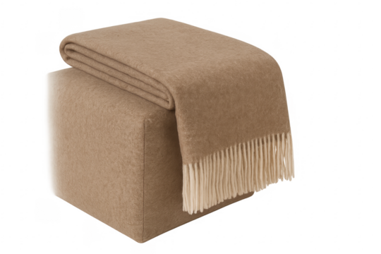 Beige wool throw blanket with tassels on ottoman