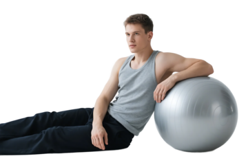 A young man is doing exercise with a fitness ball, focusing on physical training and fitness improvement.