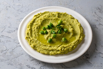 Bowl with tasty green pea hummus, lime and garlic