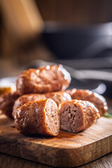 Photo of roasted italian sausage salsiccia on cutting board on wooden table.