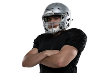 A confident male football player in helmet and black uniform with arms crossed, showcasing athletic build and determination.
