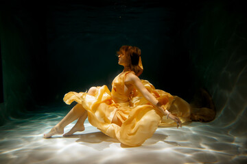 An Enchanting Underwater Dance Performance Taking Place in a Beautiful Yellow Dress