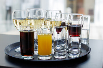 Assorted beverages on a tray displayed in a modern setting during a social event