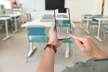 Protecting children's right to privacy in digital environment. Man taking photo of empty classroom in school, closeup