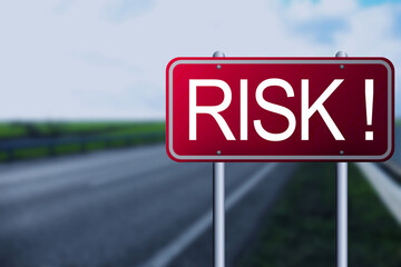 Red road sign with word Risk outdoors