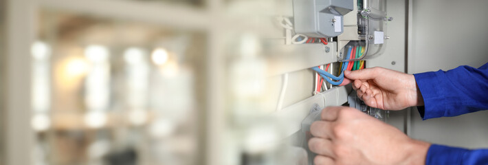 Electrician installing electricity meter indoors, closeup. Banner design