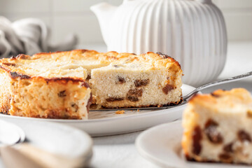 Homemade cottage cheese casserole pie with raisins. Baked cheesecake for healthy breakfast on white table background