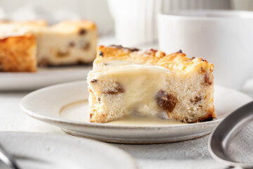 A piece of homemade cottage cheese casserole pie with raisins close up. Baked cheesecake for healthy breakfast on white table background