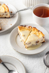 A piece of homemade cottage cheese casserole pie with raisins. Baked cheesecake for healthy breakfast on white table background